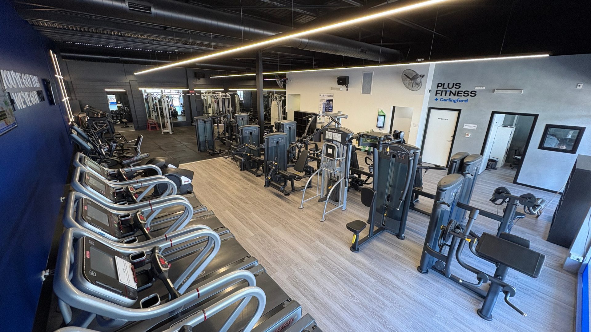 The main training floor at Plus Fitness Carlingford, cardio along one side and machines down the other