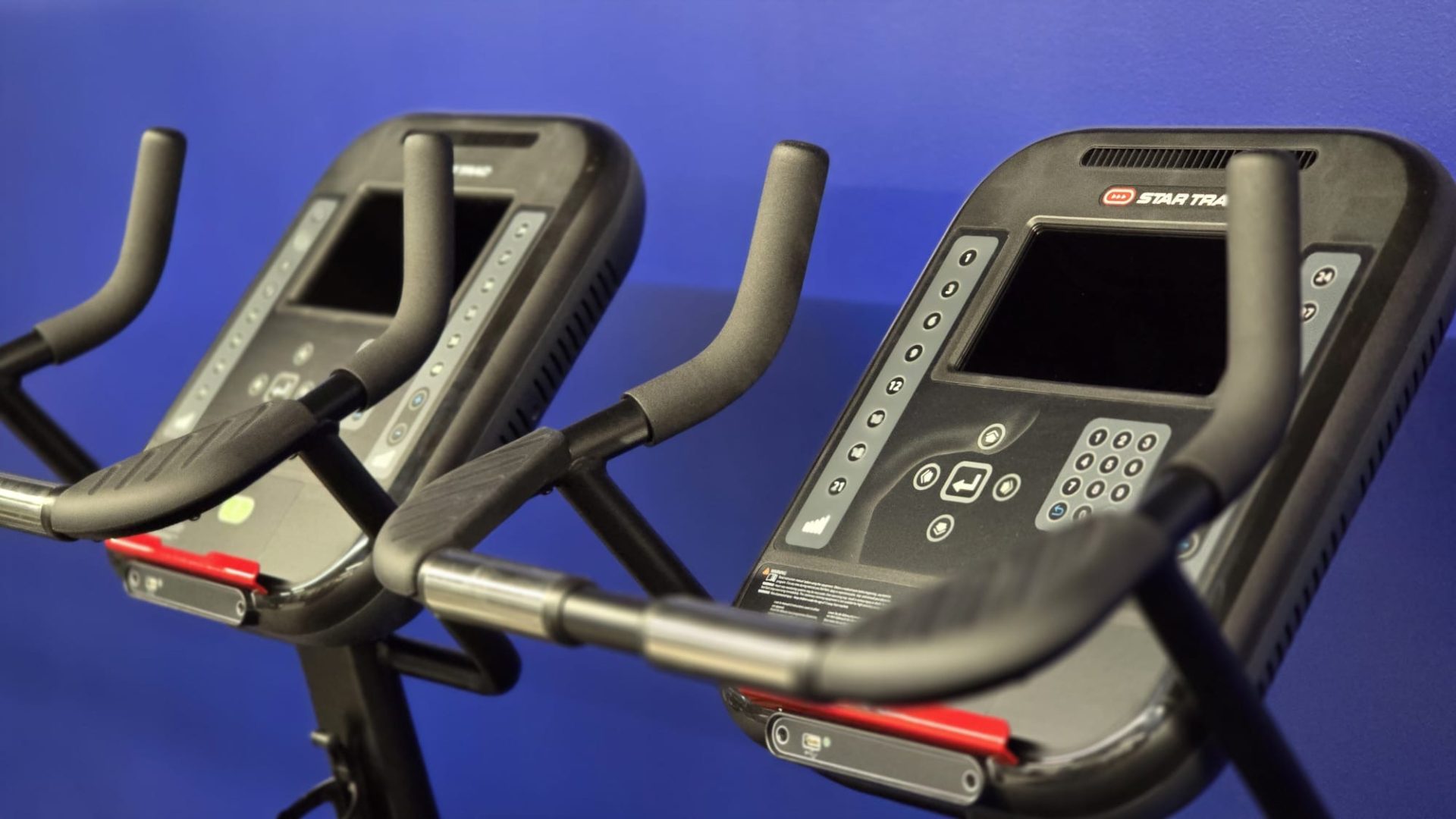 Cardio console and handlebars against the blue wall