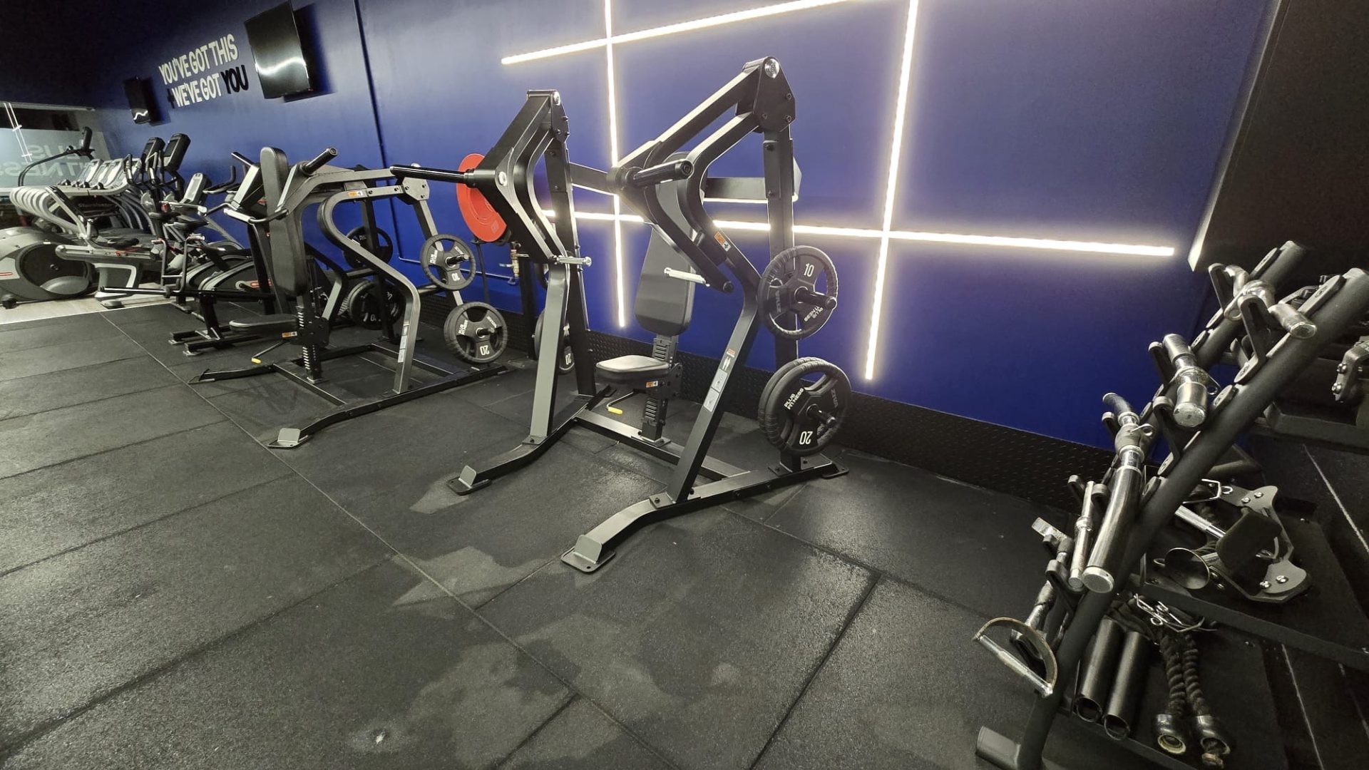 Row of plate-loaded machines lit by strip lighting